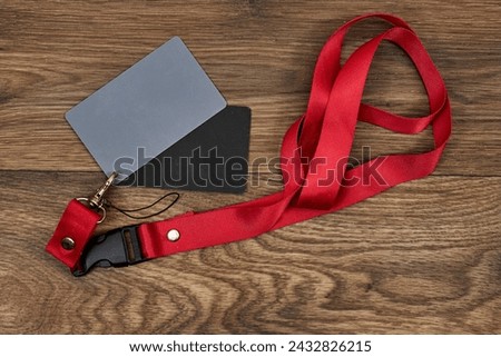 Grey card with a red strap on wood table, a photographer’s tool, determining the correct white balance