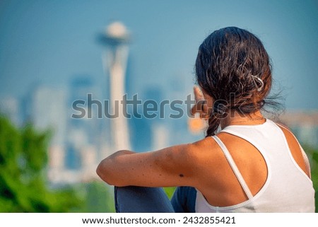 A woman mesmerized by Seattle skyline.