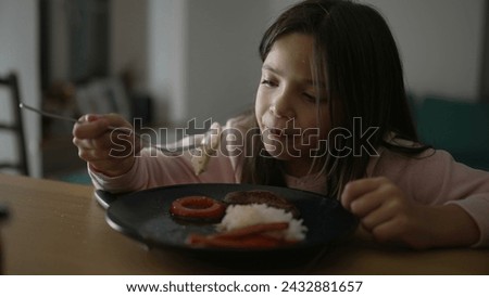 Little girl eating dinner at home. Child enjoying evening homemade plate. 8 year old kid dining Royalty-Free Stock Photo #2432881657