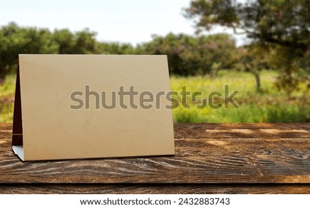 Mock up Label the blank menu frame in Bar restaurant. Stand for booklet with white sheet paper acrylic tent card on table with blurred background can inserting the text or picture