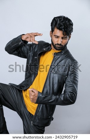 Photo of a handsome middle eastern man in black leather jacket and a yellow t shirt