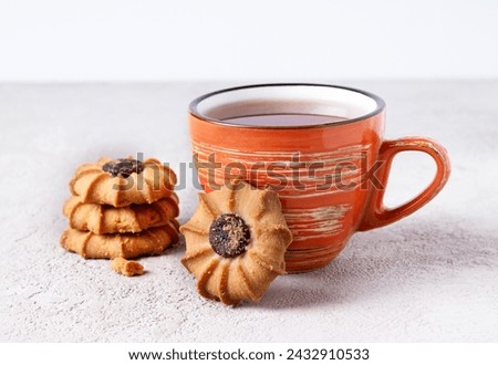 orange mug with tea and kurabye cookies, copy space