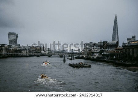 Moody London skyline featuring the Shard, Walkie-Talkie, and distant Canary Wharf, with the Thames River in the foreground