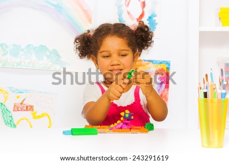 Little Hispanic looking girl play with plasticine