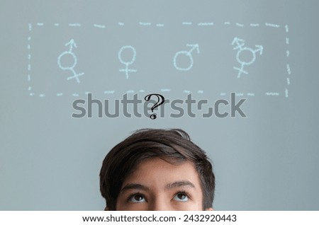 Gender confusion in teenager. A teen boy look up at gender symbols of male bigender and transgender. Concept of choice gender confusion or dysphoria.	