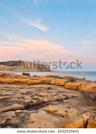 Natural pastel colors of the sky at the ocean, rocky ocean bay, purple heaven 