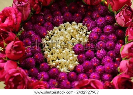 Arrange and decorate flowers on a tray to serve as a background for a heart picture.