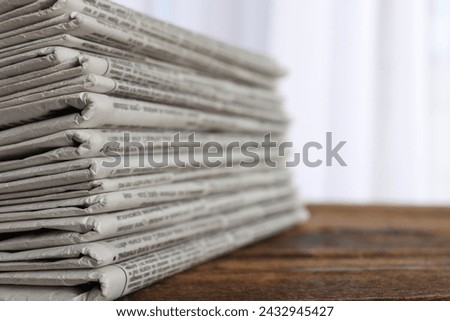 Stack of newspapers on wooden table, closeup. Journalist's work