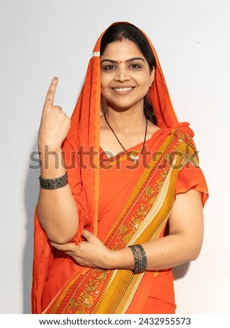Indian happy rural women smiling and showing voting sign white background.