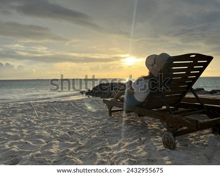 This picture is a beach view showing sunset and a girl watching sunset