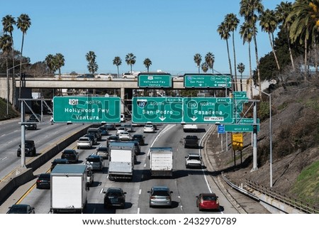 View of Los Angeles traffic and highway signs at the Hollywood 101 freeway interchange with the Pasadena and Harbor 110 freeways.