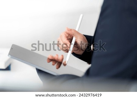 Classic image of a laptop or iPad A pen is used to design or write a business plan and draw ideas from the hands of a female executive in a suit in the office to apply in the present and future.