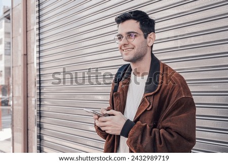 portrait of young man on the street with mobile phone