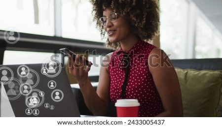 Image of media icons over african american businesswoman in office. Global business and digital interface concept digitally generated image.