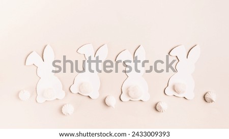 Happy Easter white decorative bunnies and mini meringues on pink background top view web banner
