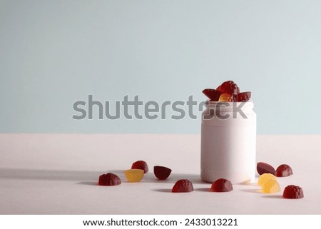chewable supplements, nutritional gummies, edible health concept. colorful marmalades and bottle for your mock up or design. copy space Royalty-Free Stock Photo #2433013221