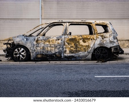 A completely burned out vehicle abandoned on the street