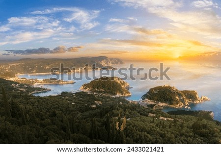 Dramatic sunset skies ignite over Paleokastritsa emerald bay, showcasing the mesmerizing natural beauty of the Greek Isles.