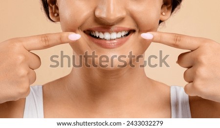 Oral Care. Beautiful Young Indian Woman Pointing At Her Smile With Two Fingers, Joyful Eastern Female Showing White Teeth, Standing Against Beige Studio Background, Cropped Shot, Closeup Royalty-Free Stock Photo #2433032279