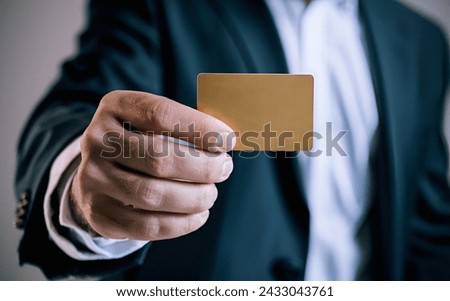 Man's hand in suit holding a gold credit card, High-resolution product, Close up.