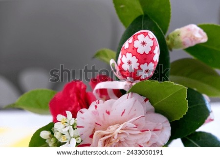 Easter egg and spring flowers in tea cup on bright pink background. Creative Easter holiday concept. Minimal greeting card with copy space for text. High quality photo