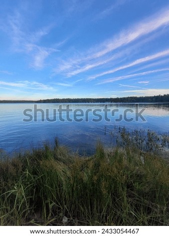 A photo of the sun setting over a lake - The photo is peaceful and quite. It looks like something that could be on a greating card  