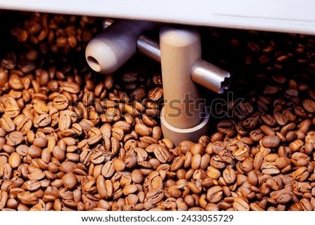 During roasting, coffee beans are prepared using oven machine for mixing raw coffee beans roasting them