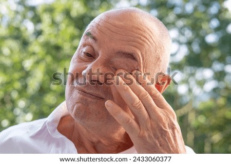 pretty man 60-65 years old with closed eyes, fatigue syndrome eye Asthenopia, eye pain symptoms, including strain, allergies, infections and injuries, sharp, dull, throbbing or burning sensations Royalty-Free Stock Photo #2433060377