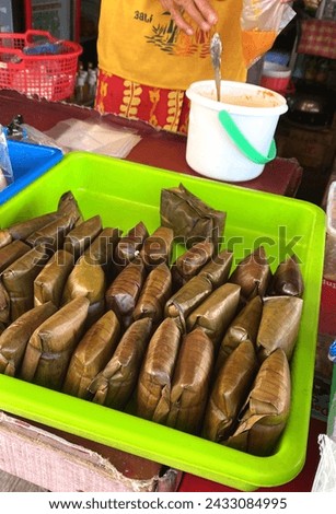 Buras is a traditional food or snack from Indonesia. Made from rice, salt and coconut milk served with peanut sauce Royalty-Free Stock Photo #2433084995