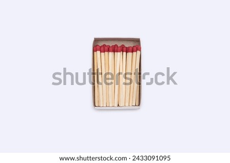Matches in a matchbox. An open cardboard matchbox filled with matches on a white background. Top view of matches close-up with space for text. Royalty-Free Stock Photo #2433091095