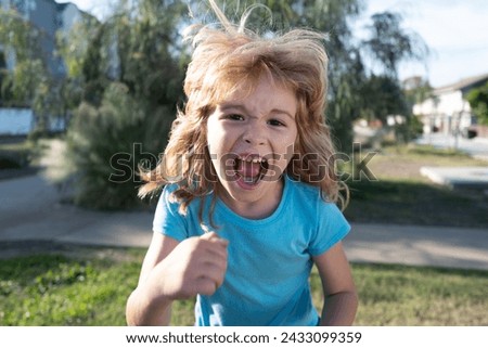 Enraged kid boy with angry expression. Angry hateful little rage boy, child furious. Angry rage kids face close up. Anger child with furious negative emotion portrait. Aggressive and mad kid behavior. Royalty-Free Stock Photo #2433099359