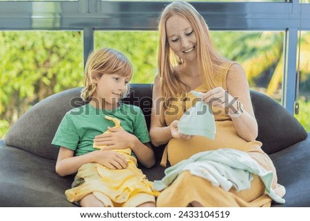 Heartwarming family moment as expectant mom and son joyfully browse through newborn baby's clothes, eagerly anticipating the arrival of a new family member