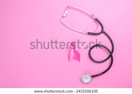 Pink ribbon breast cancer and stethoscope on pink background with copy space. Breast Cancer Awareness.