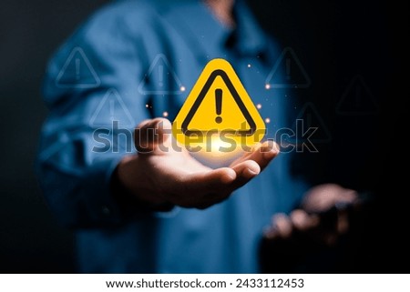 Business investment risks concept. Businessman holding warning sign on virtual screen for caution in investing economic situation warning.