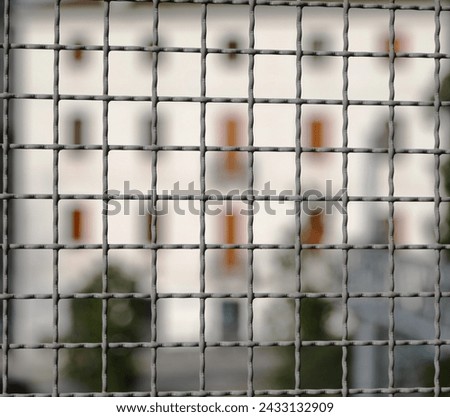 metal fence separating the border and the building intentionally blurred in the background Royalty-Free Stock Photo #2433132909