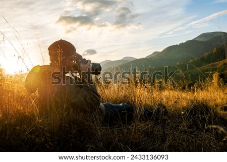 Professional nature photographer in mountain with sunset. Photography Concept