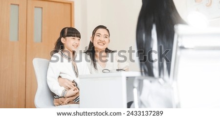 Southeast asian doctor woman interview check mom and child health care in kid clinic examining room. People at hospital and medical center concept. Royalty-Free Stock Photo #2433137289