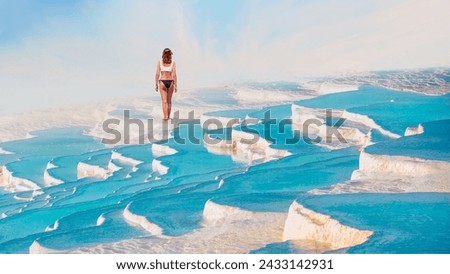 Young girl walking on the turqouise pool of travertines - Pamukkale, Turkey