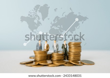 stack of coins in soft focus and blurred miniature of businessman on graph, world map background financial graph, world map and global network business concept idea