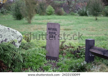 A natural burial site, marked by a beautiful piece of native wood.  Royalty-Free Stock Photo #2433150099