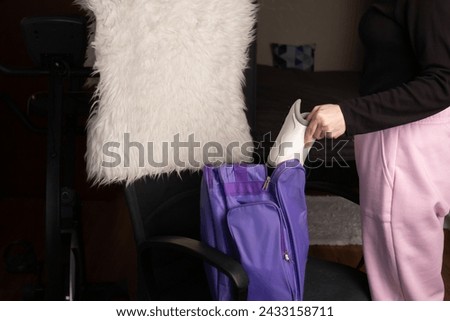 Female hands putting away skates in a sports bag, ice skate storage, winter sports equipment, woman preparing for leisure Royalty-Free Stock Photo #2433158711