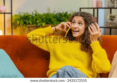 Phone call, good news, gossip. Happy surprised 14-15 years child girl in pleasant conversation on smartphone, enjoying talking with friend. Teenager Caucasian female kid at home room apartment on sofa Royalty-Free Stock Photo #2433172555