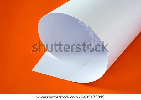 
A sheet of large format white paper on an orange background.