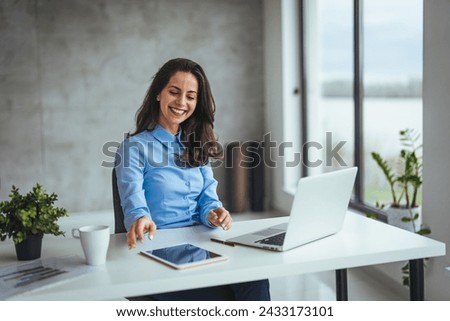Woman working on laptop online, checking emails and planning on the internet while sitting in an office alone at work. Business woman, corporate professional or manager searching the internet