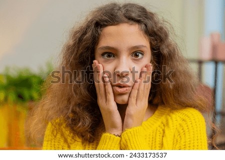 Oh my God, Wow. Caucasian surprised 14-15 years school girl looking at camera with big eyes shocked by sudden victory, good win news celebrating. Excited amazed child kid at home room apartment indoor Royalty-Free Stock Photo #2433173537