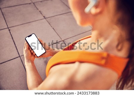 Mockup, fit athletic woman holding mobile phone with blank screen during outdoor workout