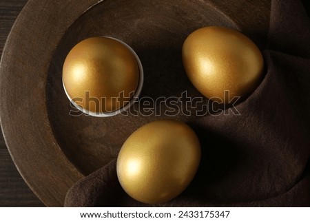 Golden eggs on the table in a bowl on a brown background