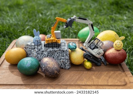 Easter spring holiday concept. postcard from construction companies. toy models of construction equipment - excavators and colored eggs