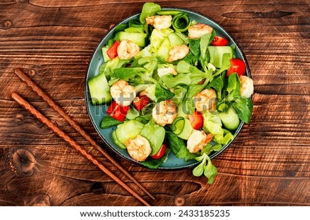 Plate with fresh salad of vegetables, herbs and shrimp or prawns. Prawn salad on wooden table Royalty-Free Stock Photo #2433185235