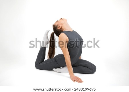 Young beautiful woman doing stretching exercise on white background. Studio shot.